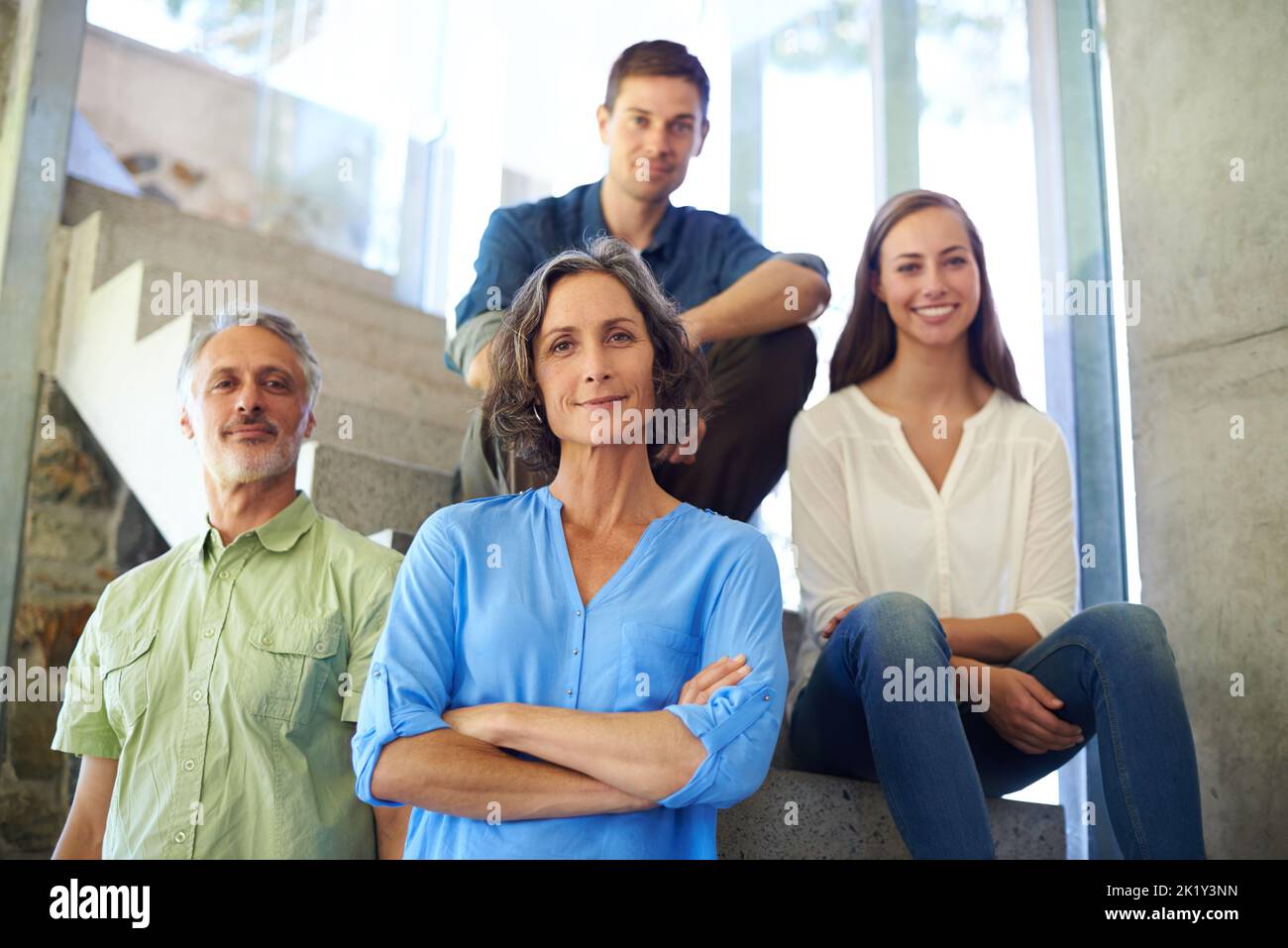 Our focus is always on the happines of our family. a mother and father standing in front of their adult children on the stairs. Stock Photo