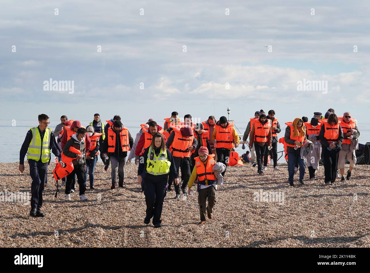 EDITORS NOTE: The PA Picture Desk has been unable to gain the necessary permission to photograph children under 16 on issues involving their welfare. This image has been provided unpixelated for customers to pixelate in their own style. A group of people thought to be migrants walk up the beach in Dungeness, Kent, after being rescued in the Channel by the RNLI following following a small boat incident. Picture date: Wednesday September 21, 2022. Stock Photo