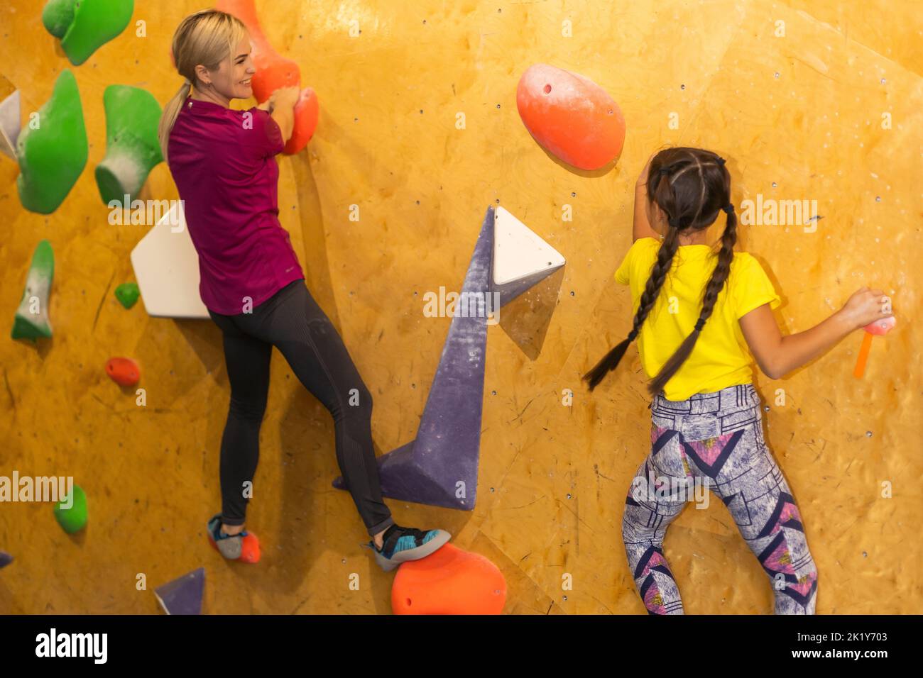 Instructors Helping Children Climb Wall In Gym Stock Photo Alamy