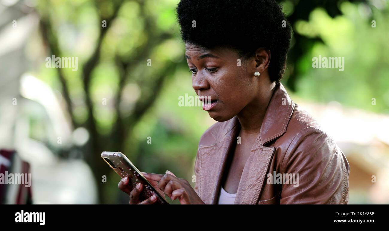 Happy African woman receiving positive message or notification on ...
