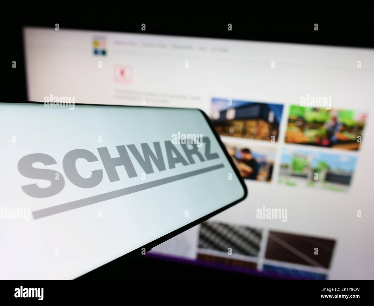 Smartphone with logo of German retail company Schwarz Group on screen in front of business website. Focus on left of phone display. Stock Photo