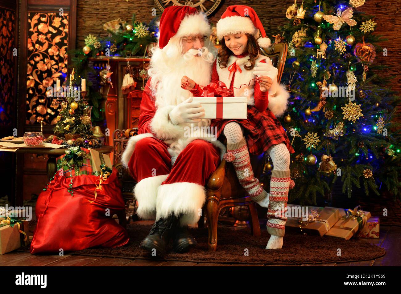 Santa Claus in a traditional costume with a girl in a room Stock Photo