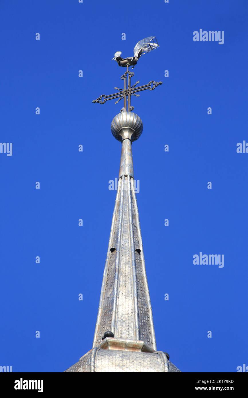 Sculpture d'un coq sur une croix en fer forgée. Eglise Saint-Nicolas de Combloux et son clocher à bulbe classé au titre des monuments historiques en 1 Stock Photo