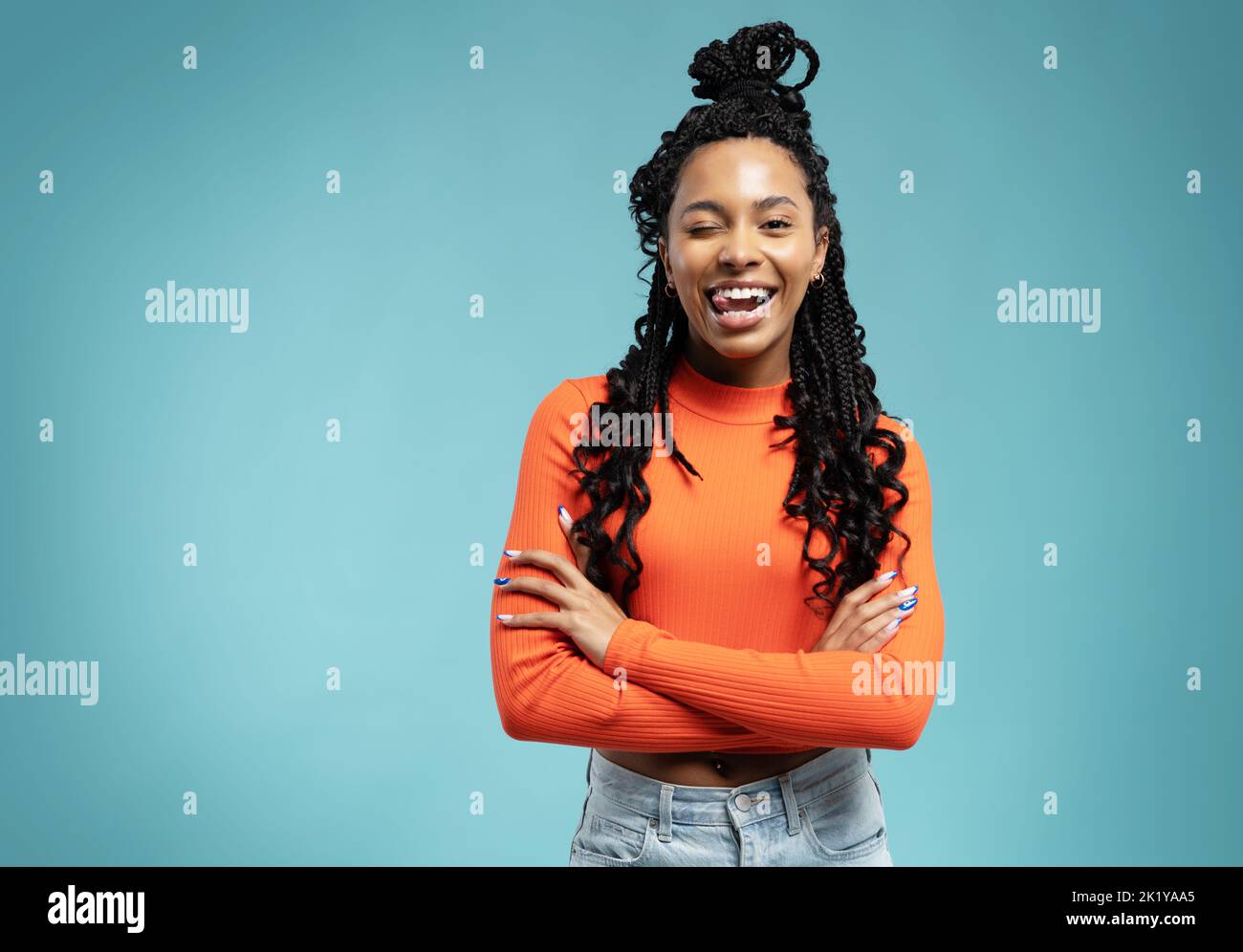 Young lovable woman with african hairstyle laughing during indoor photoshoot. Graceful cute girl in casual clothes enjoying leisure time in studio. Stock Photo