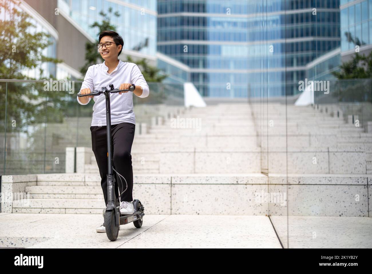 Young man riding electric scooter downtown Stock Photo Alamy