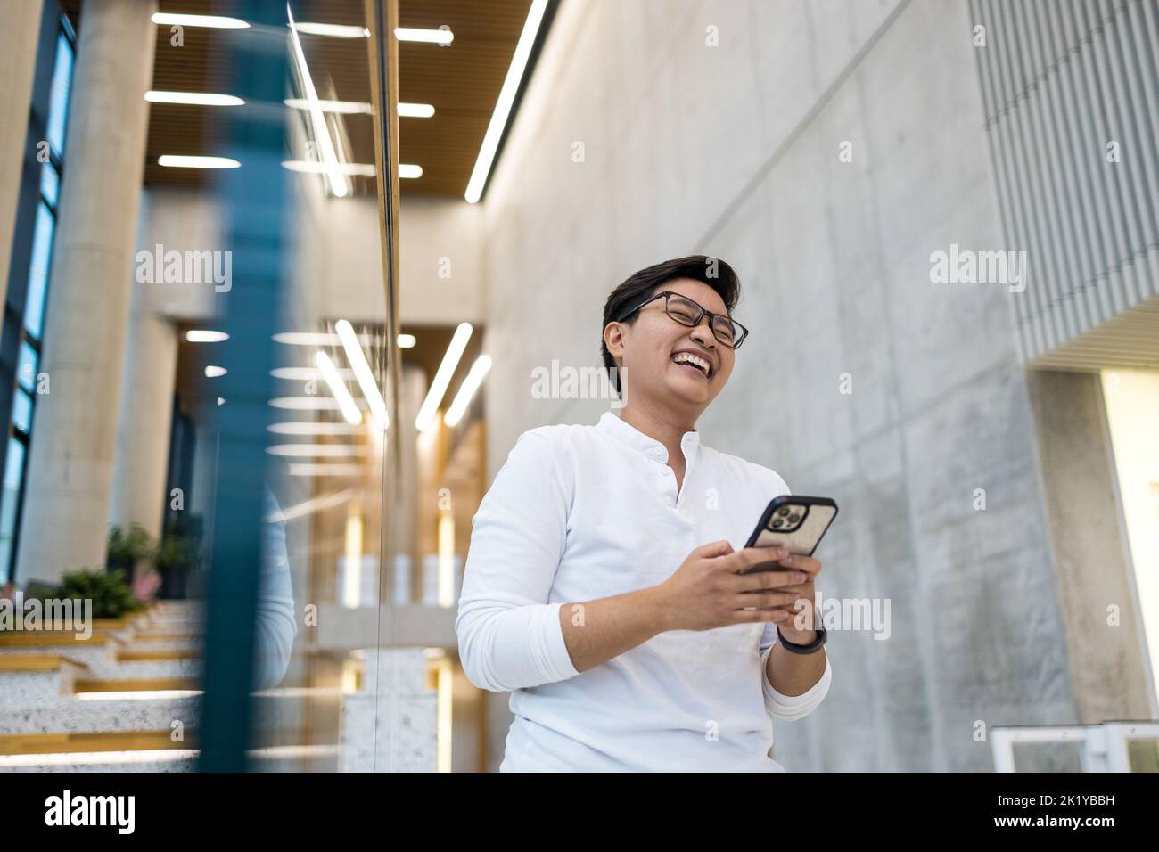 Smiling young man using mobile phone Stock Photo