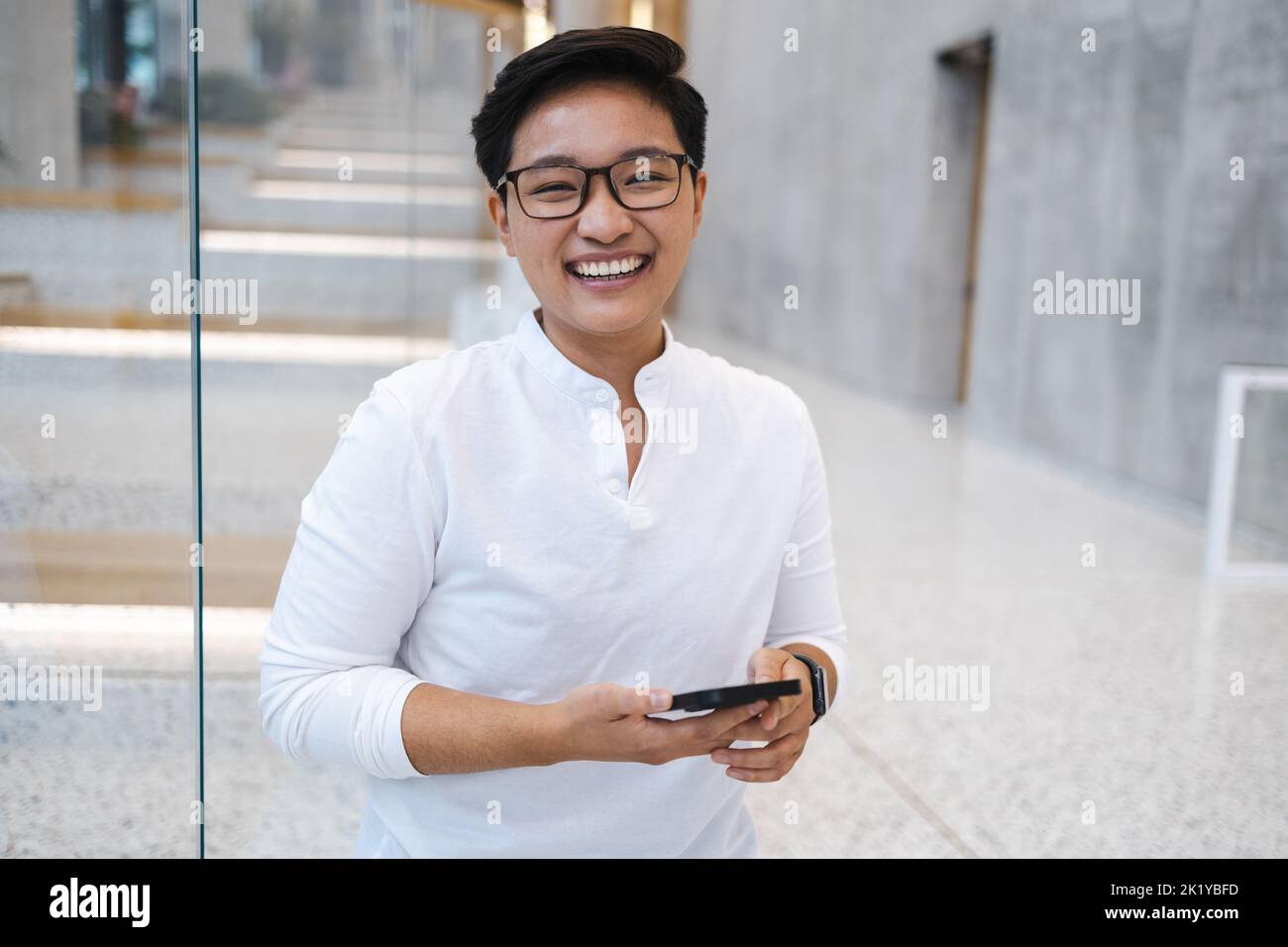 Smiling young man using mobile phone Stock Photo