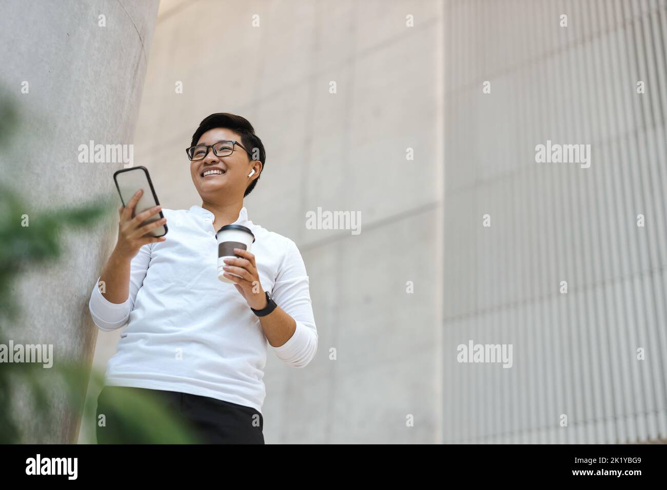 Smiling young man using mobile phone Stock Photo