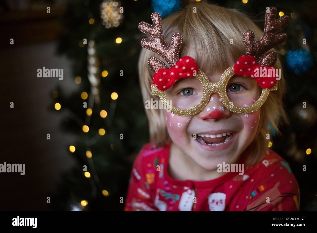 Smiling happy child in a festive make-up of a deer. The kid is waiting for a miracle. Christmas, New Year, merry winter holidays, pampering at home. h Stock Photo