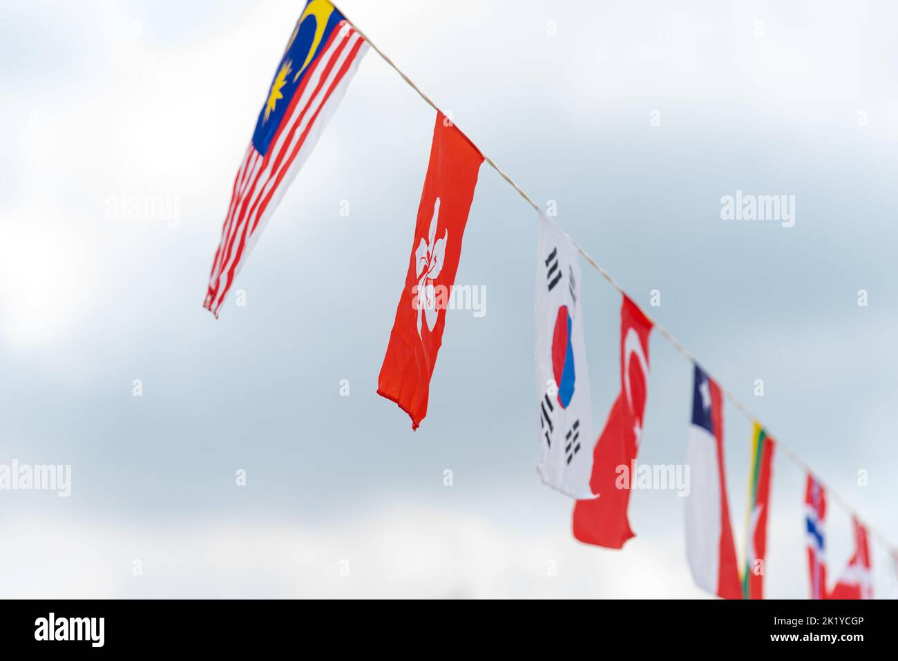 Countries flags banners hanging on a rope line for festivals. Stock Photo