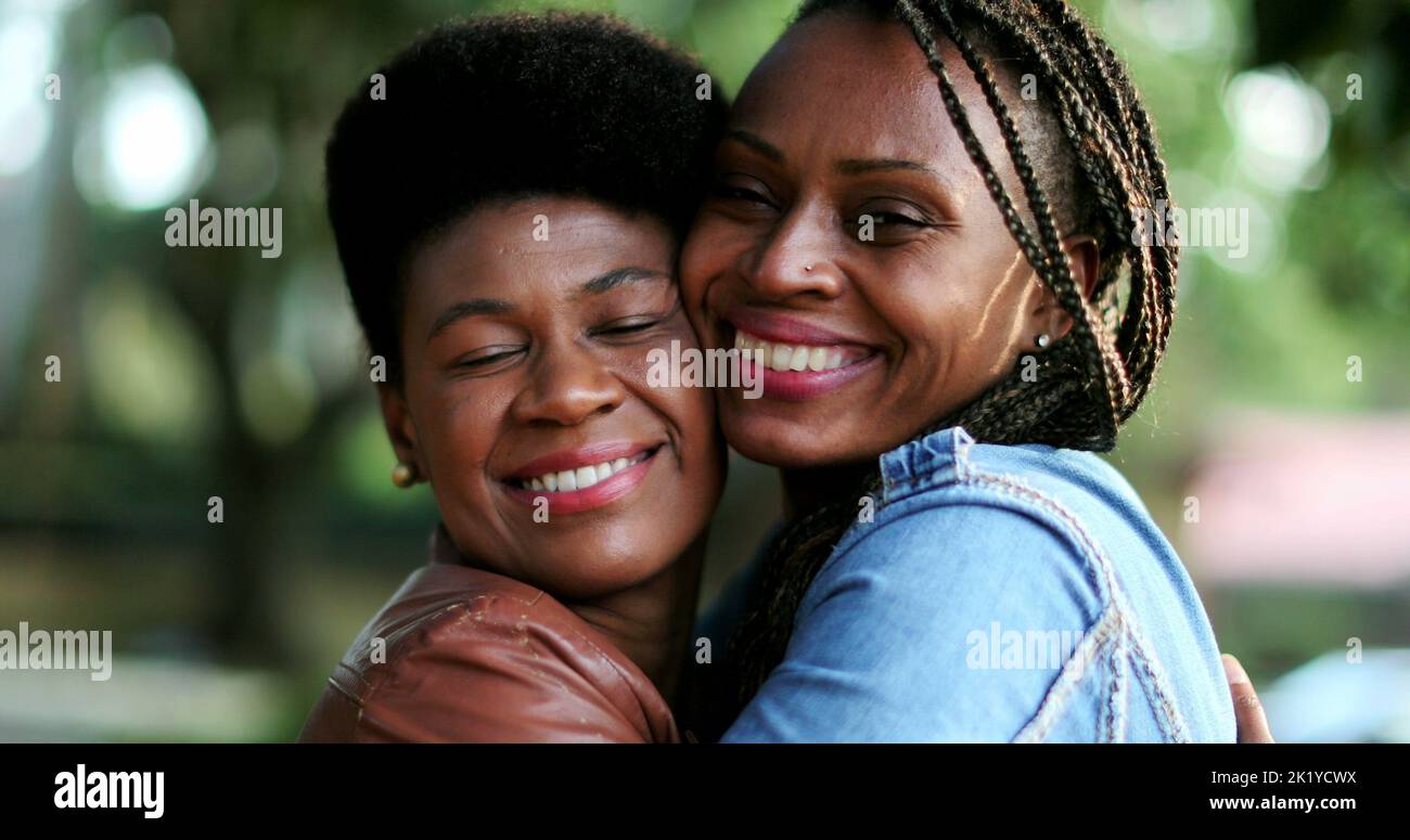 Two female friends, African women kissing friend in cheek Stock Photo ...