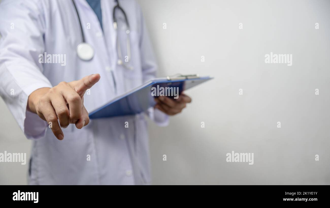 Doctor pressing button on virtual screen on background copy space for text. Stock Photo