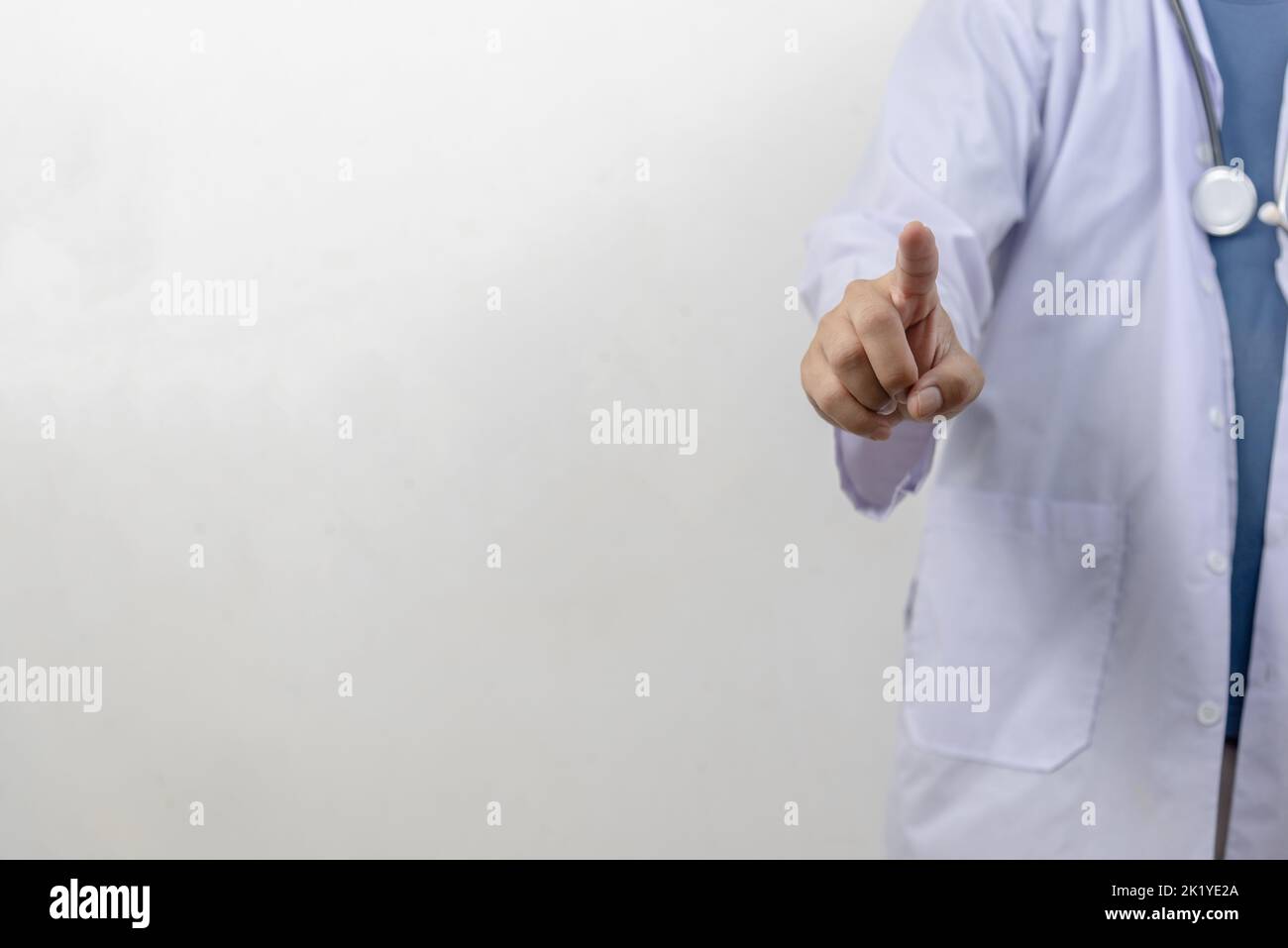 Doctor pressing button on virtual screen on background copy space for text. Stock Photo