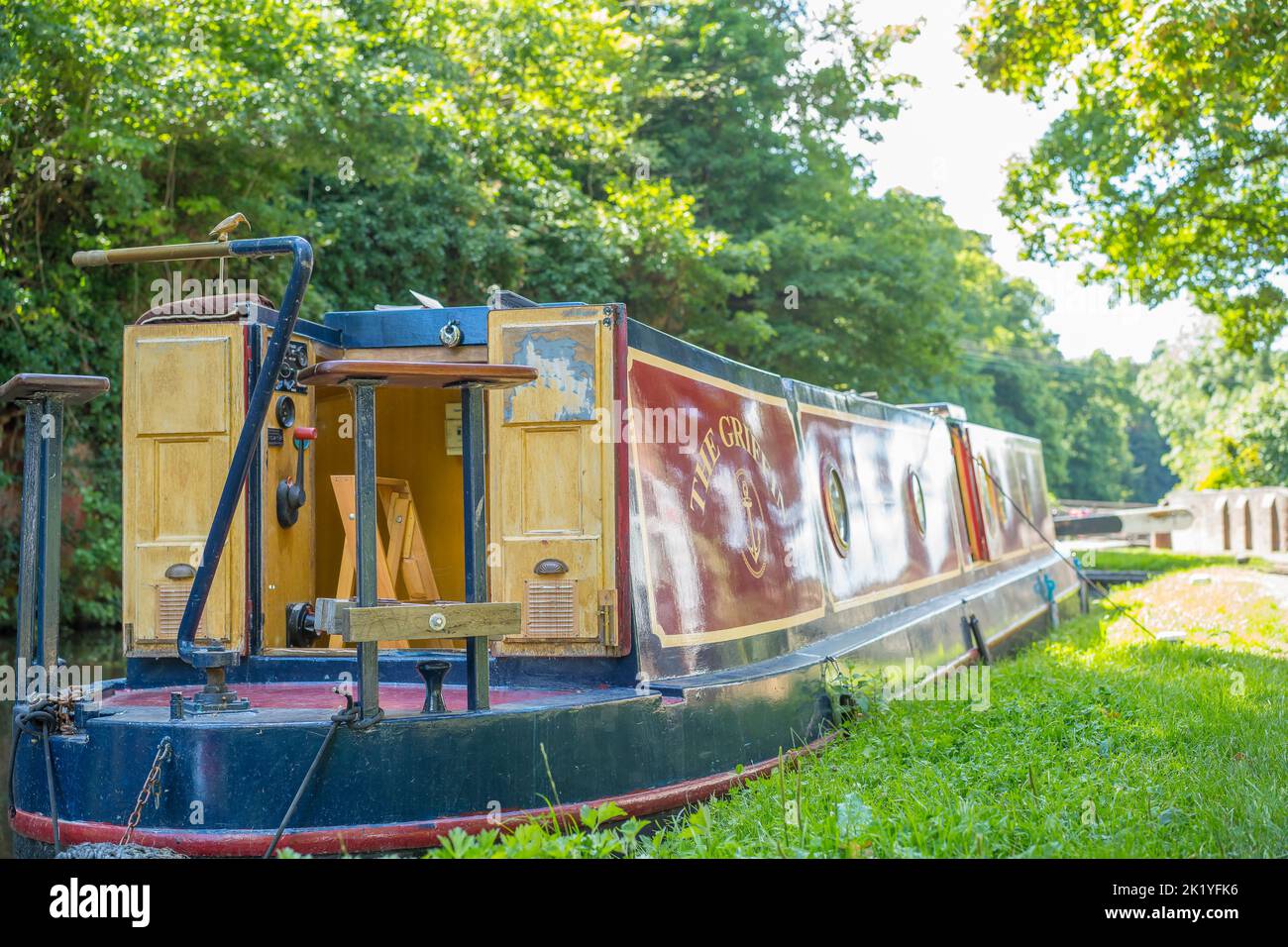 Rear view of a canal boat moored up on a canal with the rear doors open. No people, boat only. Stock Photo