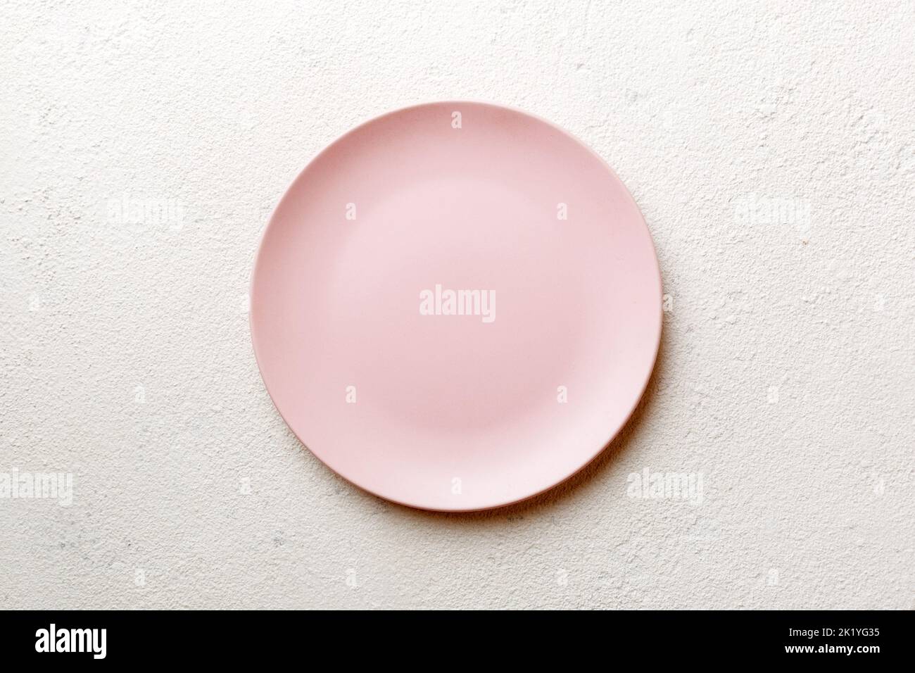 Top view of empty pink plate on cement background. Empty space for your ...