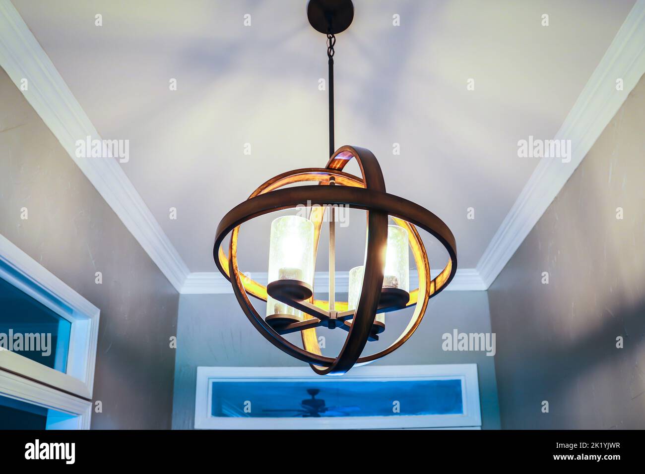 A suspended hanging orb light fixture in a front entrance of an Acadian style home or house. Stock Photo