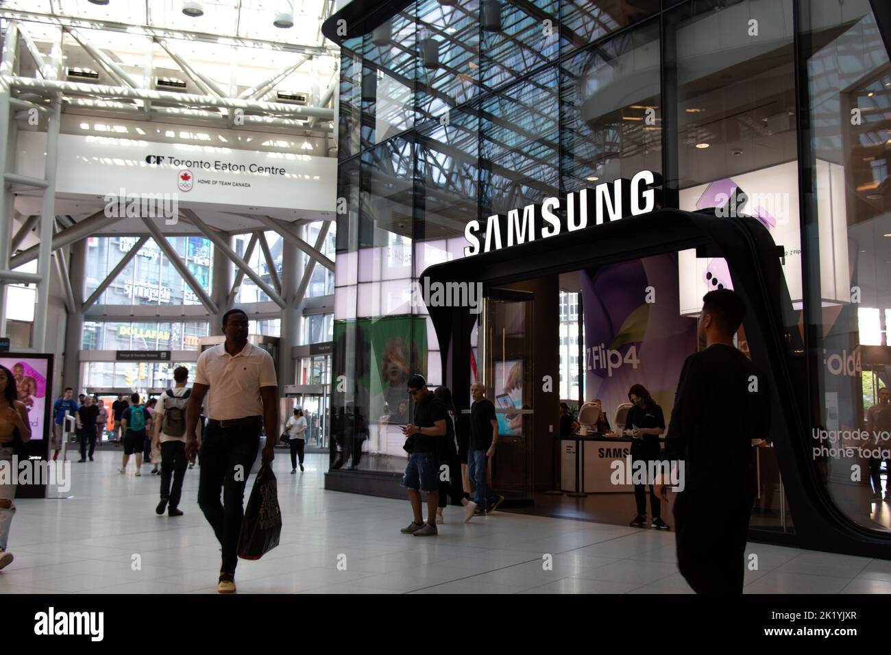 Shoppers pass by the front of a Samsung Experience store in Toronto Eaton Centre. Stock Photo