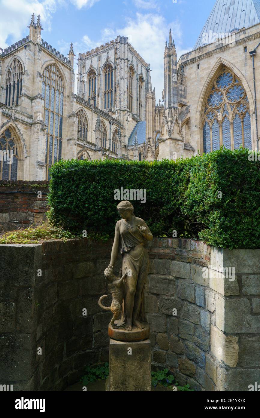 Treasurer's House garden with the Fidelity female statue with her arm raised in an instruction to a dog and York Minster in the background, York, UK. Stock Photo