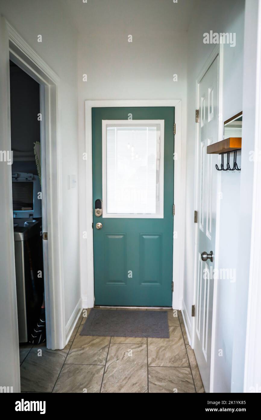A dark teal painted interior back door inside an Acadian style