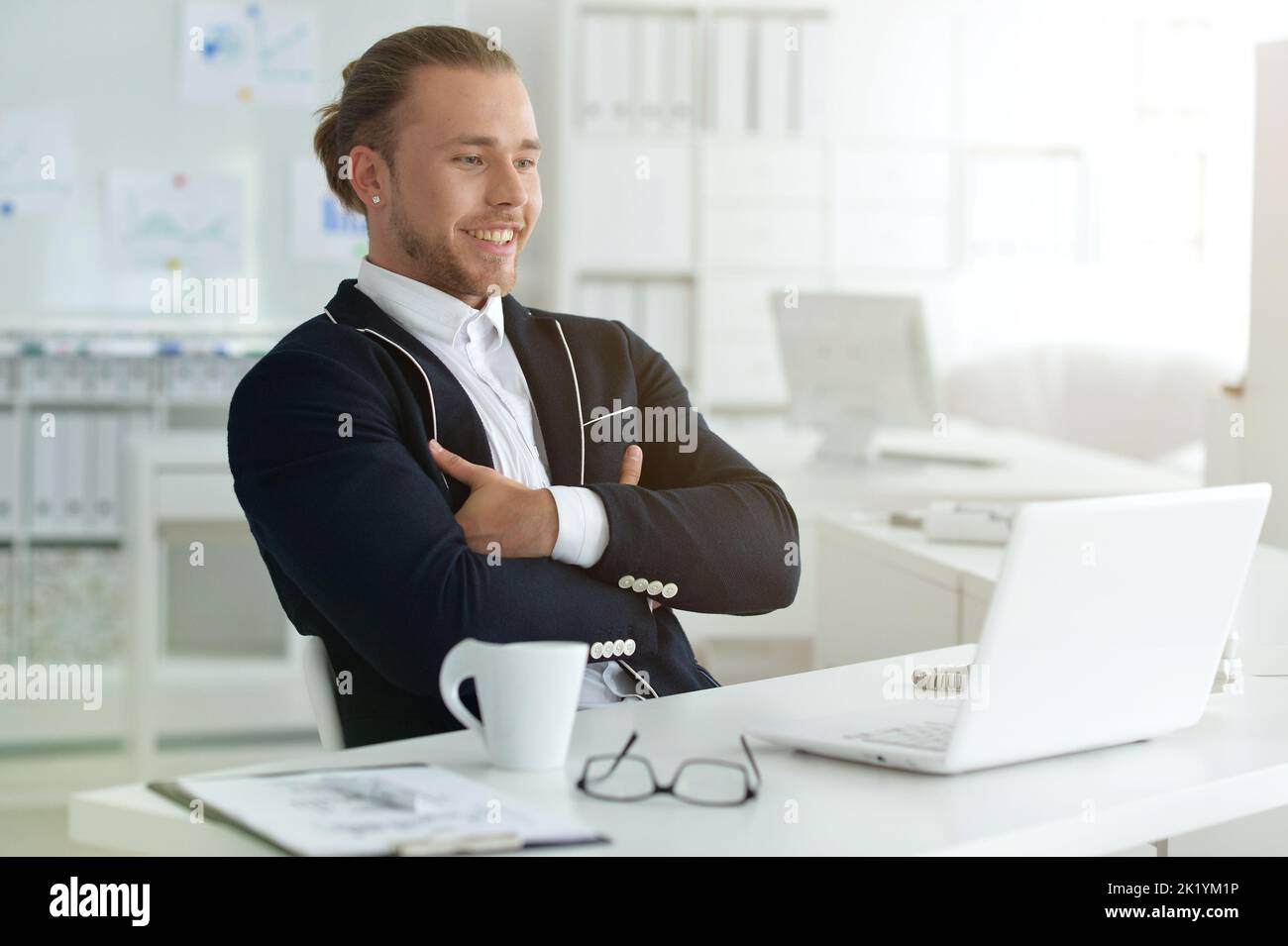 Portrait of a smiling beautiful businessman using a laptop. Stock Photo
