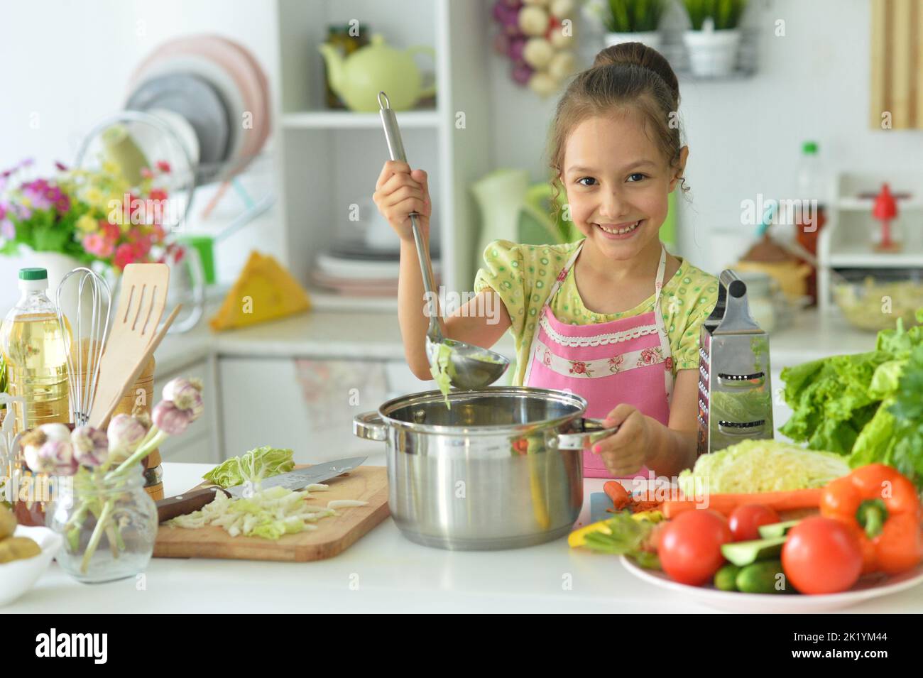 Beautiful girl preparing a salad in the kitchen Stock Photo