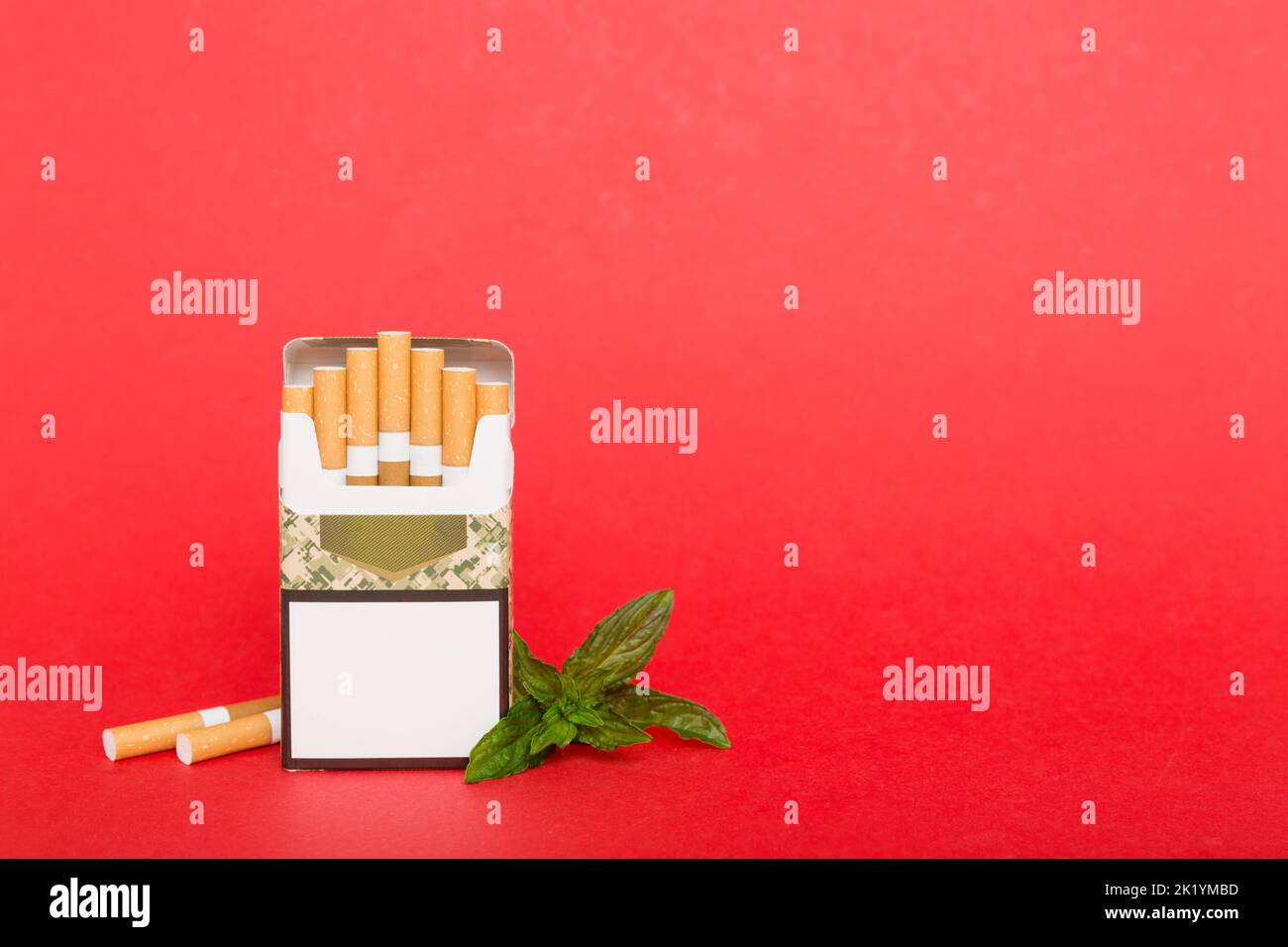 Pack of menthol cigarettes and fresh mint on colored table, Menthol