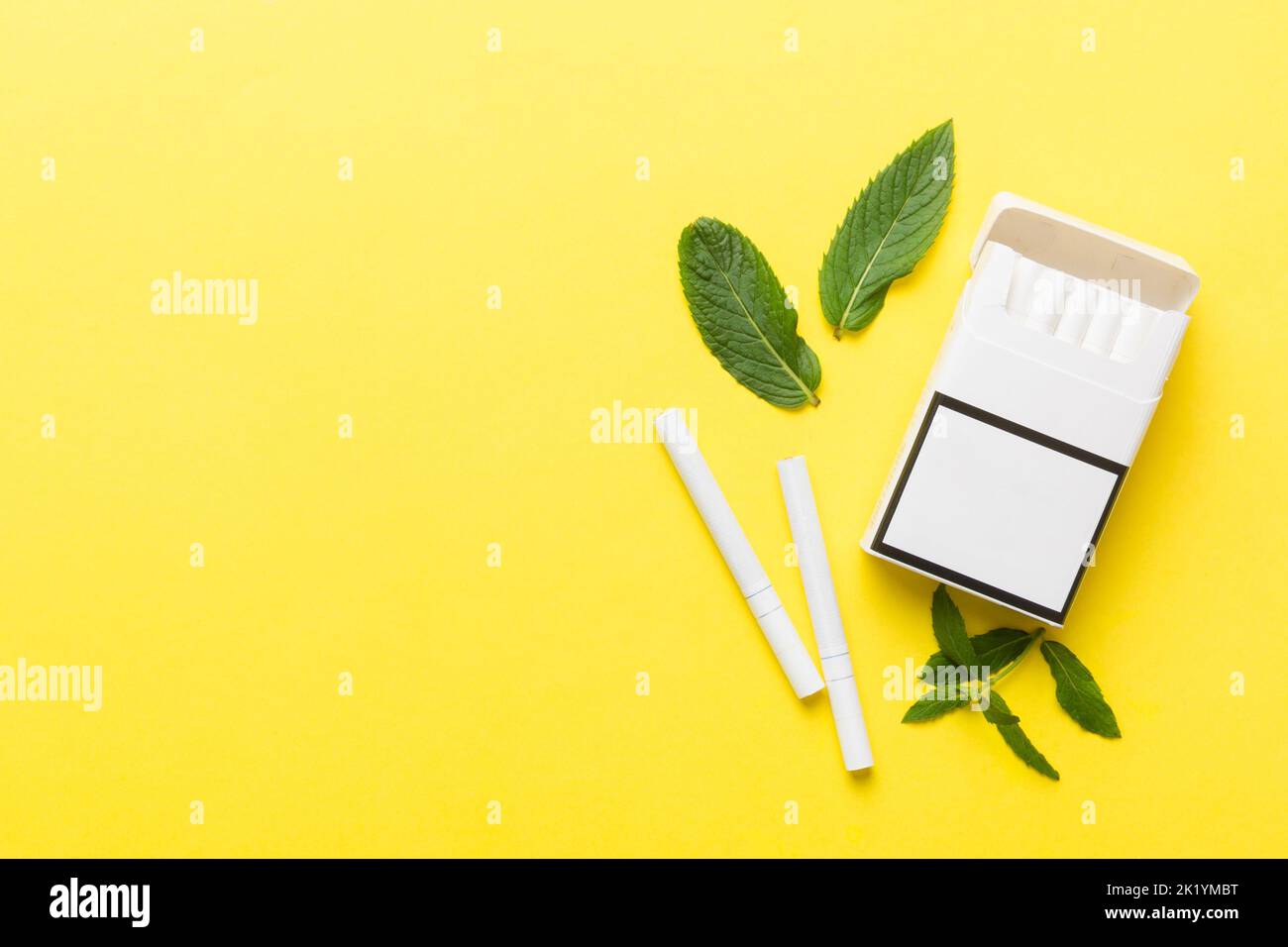 Pack of menthol cigarettes and fresh mint on colored table, Menthol