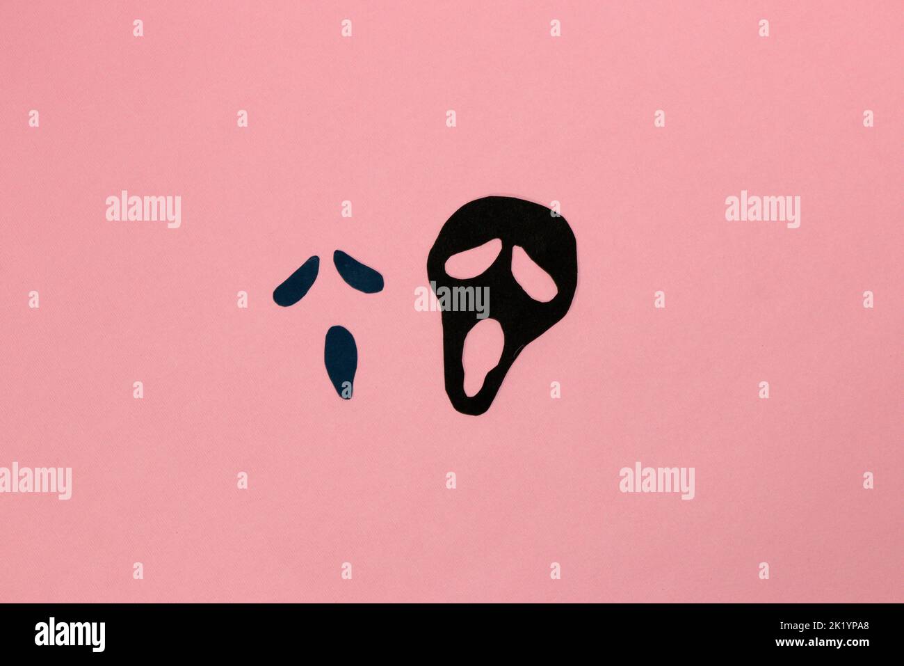 ghost face on pink background, scary halloween concept, flat lay, paper craft Stock Photo