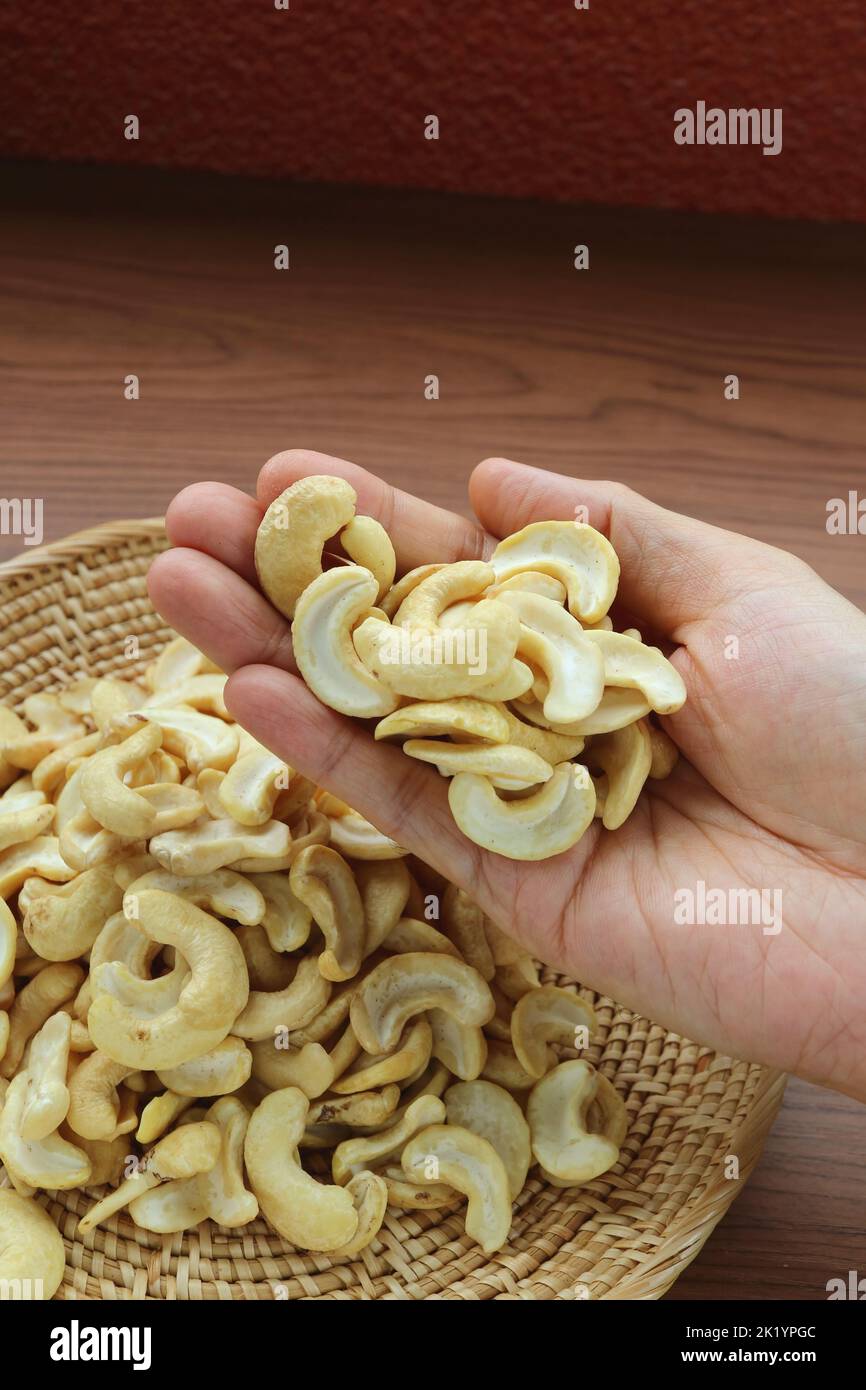 Heap of Dried Cashew Nut Kernels in Man's Hand Stock Photo