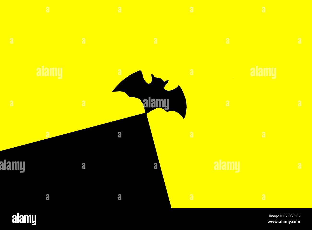 black bat on top of black part of black and yellow background, halloween concept, creative art design, paper craft Stock Photo