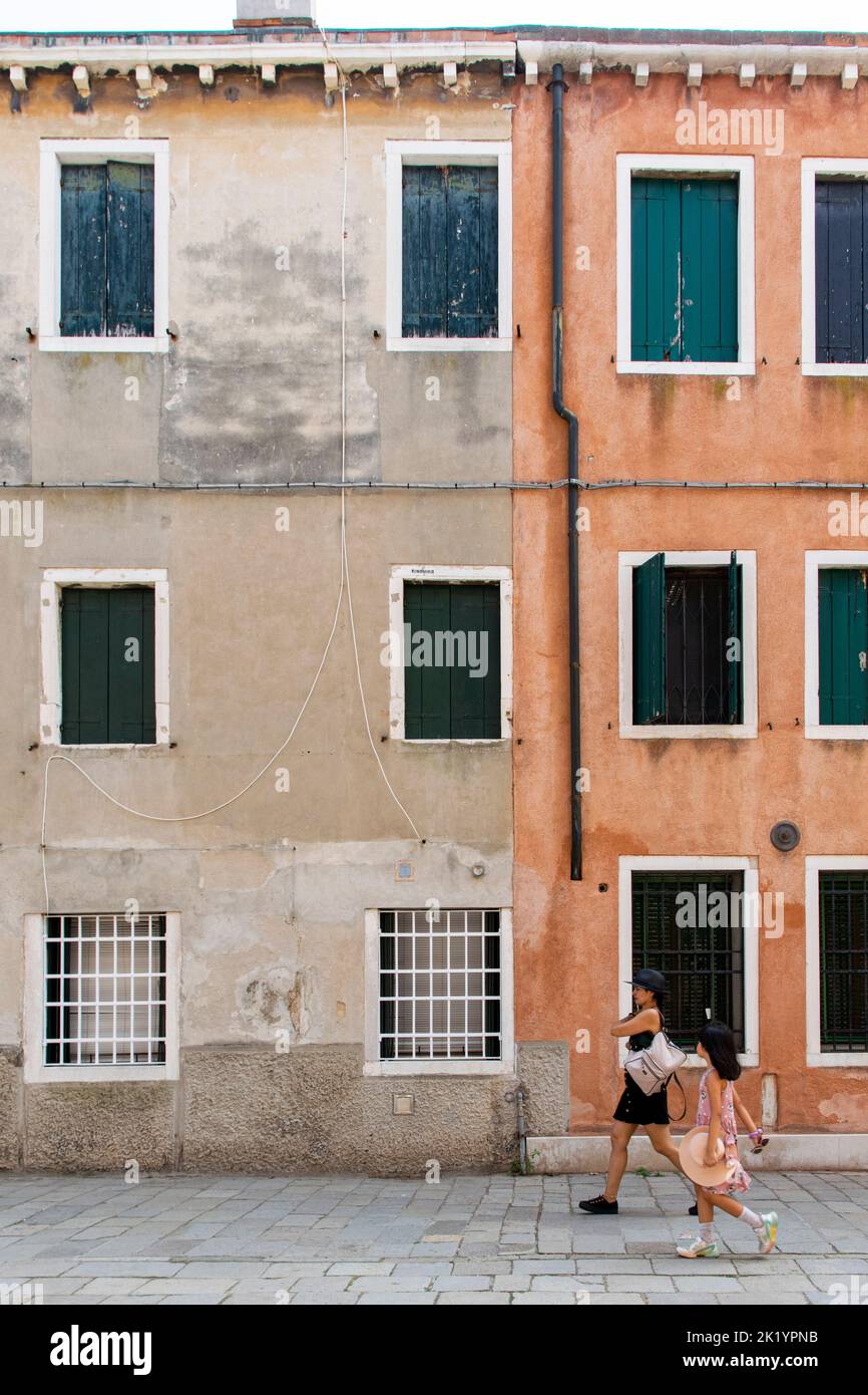 Two persons walking along the streets of Arsenale neighborhood, Venice Stock Photo
