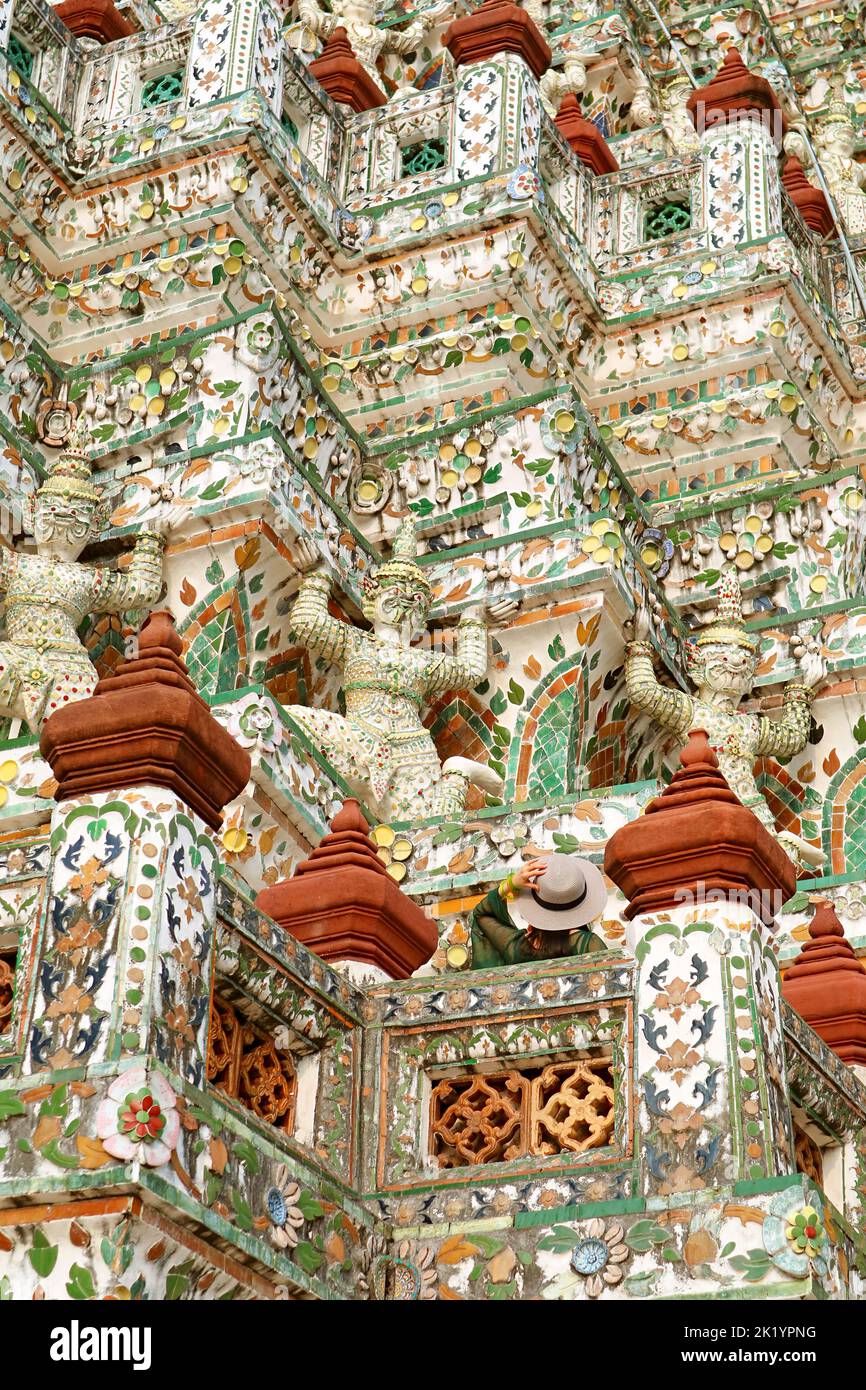 Female Traveler Admiring  Fantastic Architectural Details of the Temple of Dawn Main Prang, Bangkok, Thailand Stock Photo