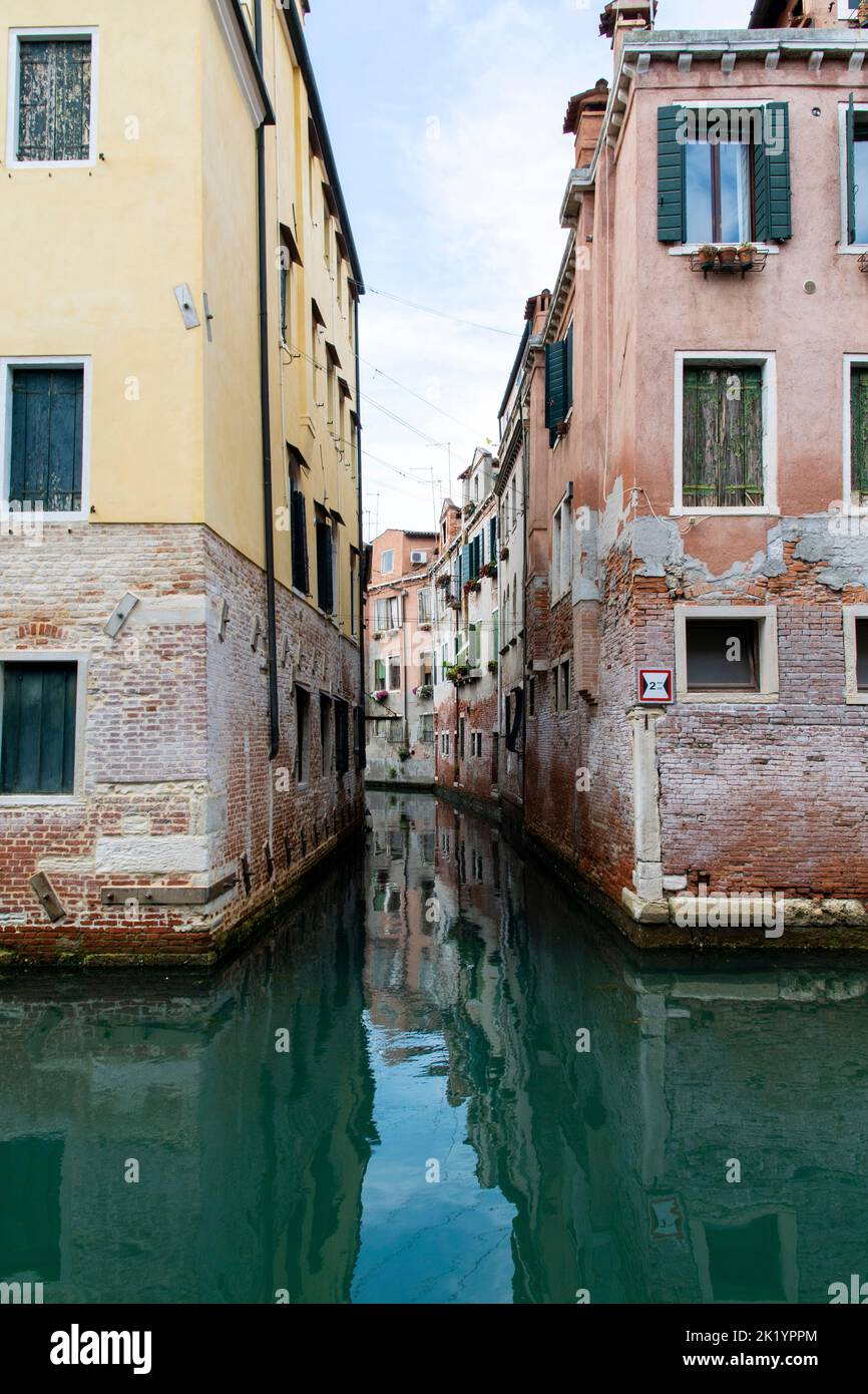 Green waters along a channel in Venice, Italy Stock Photo