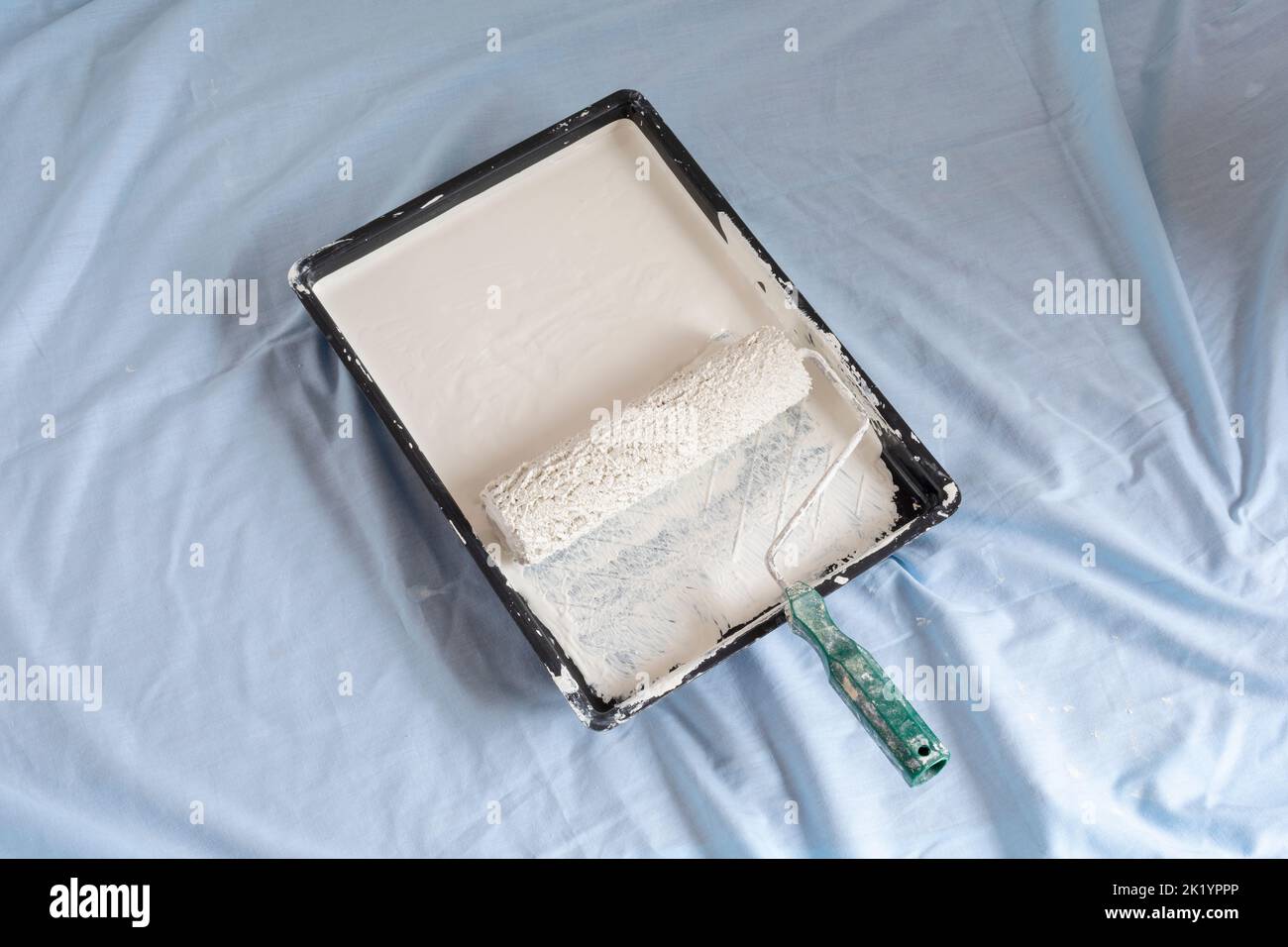 Paint tray ready to use with cream coloured paint and paint roller home decorating Stock Photo