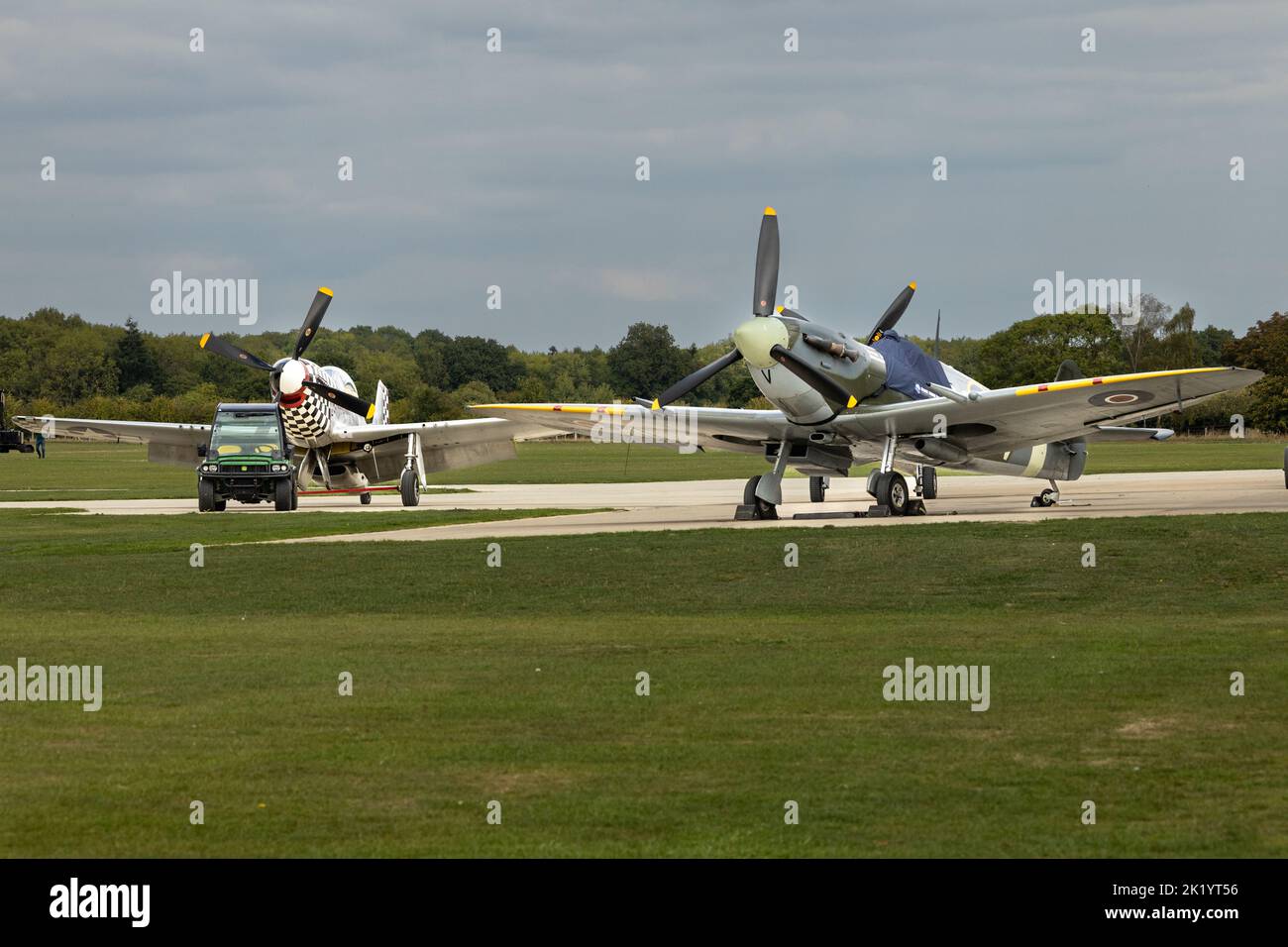 Spitfire and Mustang Second World War fighter planes on the apron at an airfield in the UK Stock Photo