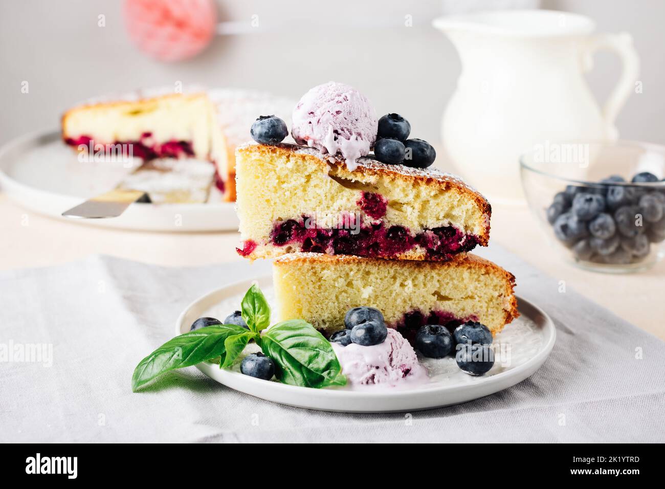 Two pieces of blueberry sponge cake with berry ice cream Stock Photo