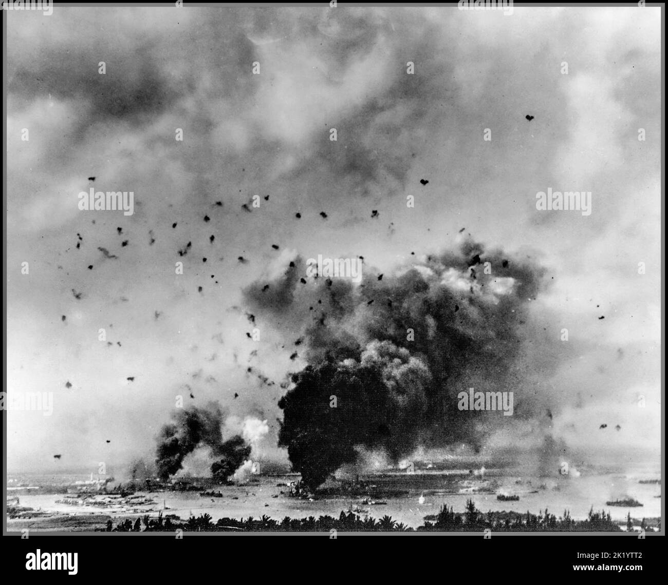 PEARL HARBOR ATTACK General view of the Japanese surprise attack with American battleships hit and burning in Pearl Harbor with anti aircraft fire filling the sky, during the infamous Japanese offensive on 7th December 1941. Stock Photo