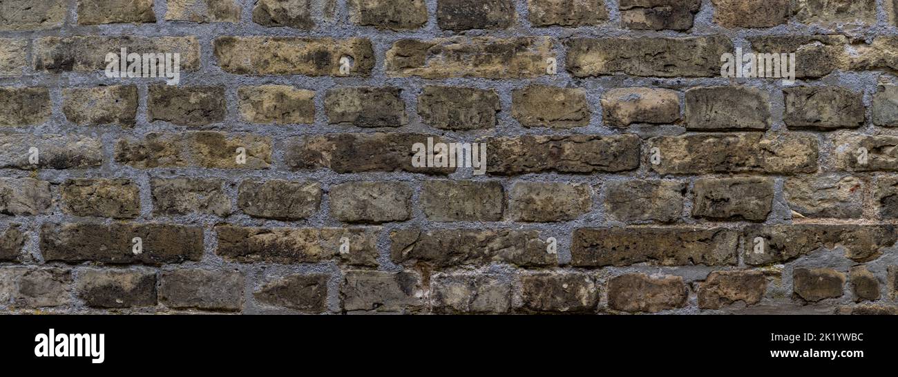 Wide weathered beige brown brick wall background Stock Photo