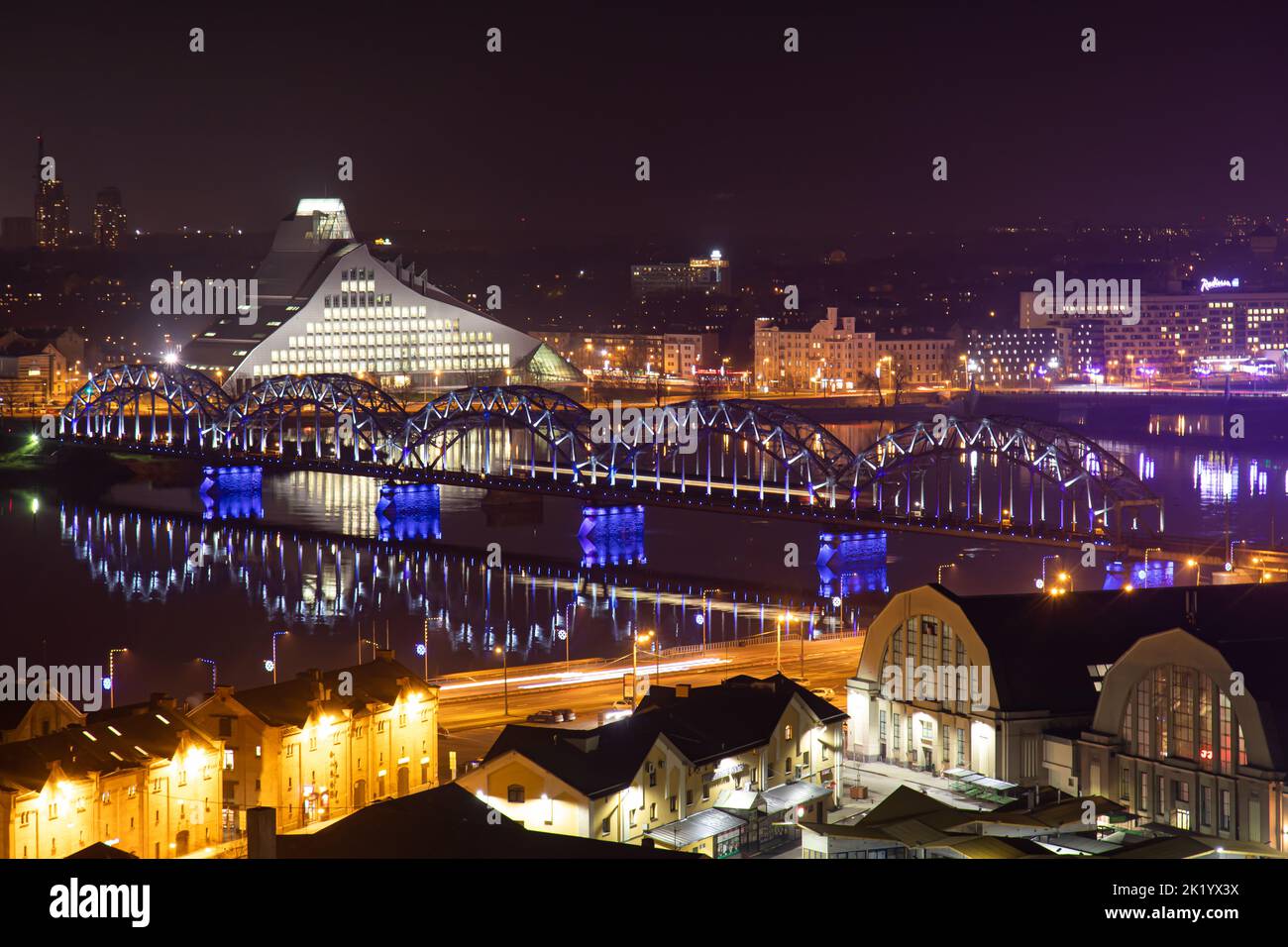 Scenic Riga Scenic night top view of Riga, with a train crossing a bridge near ...