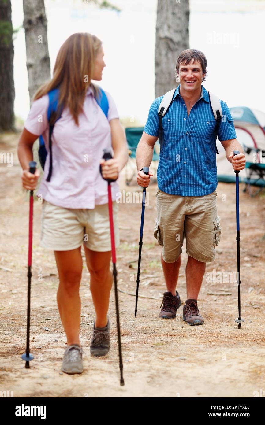 Hiking. Two hikers walking with trekking poles during their camping holiday. Stock Photo