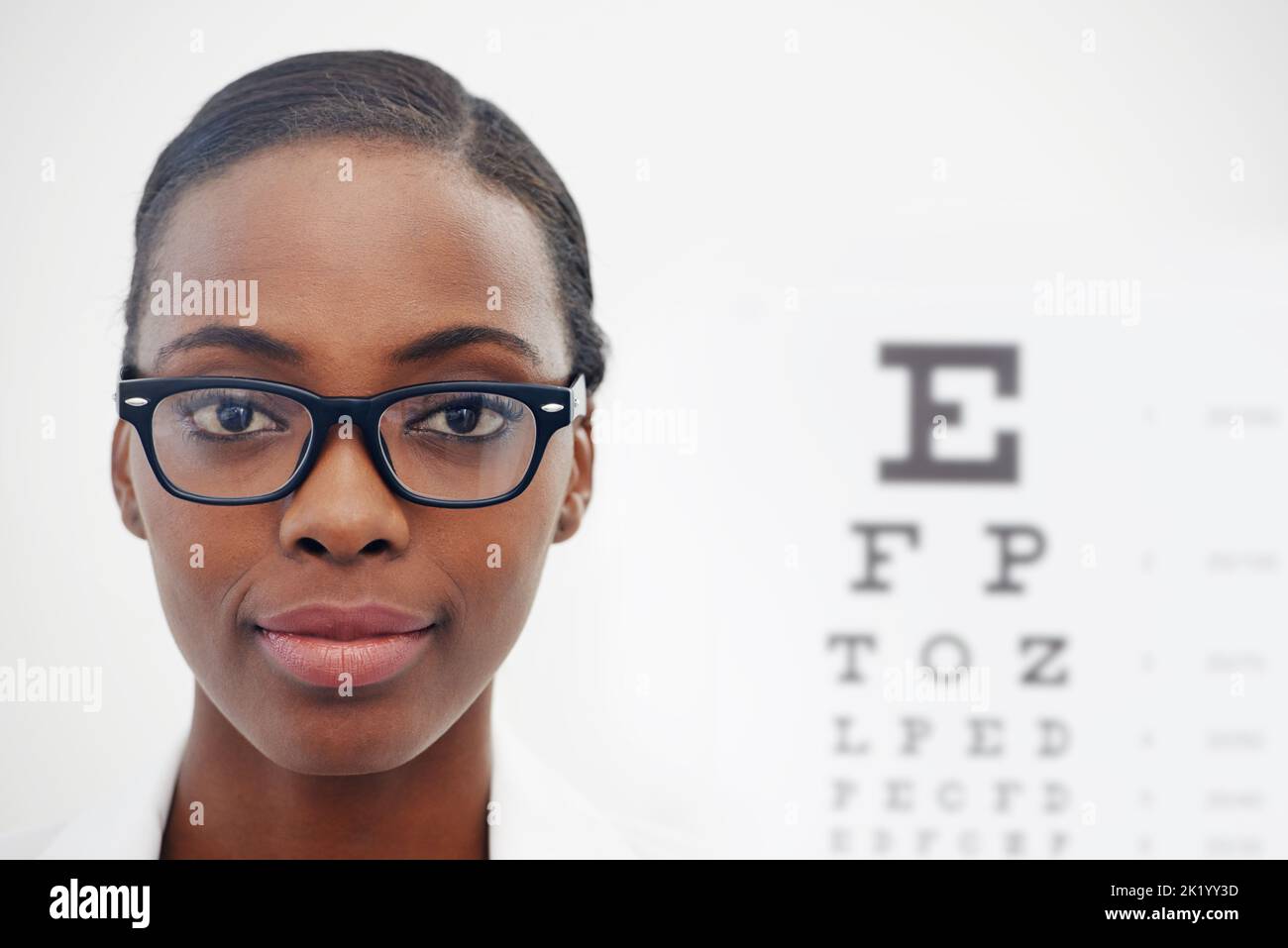 Shell get you seeing clearly. Portrait of a female optometrist standing beside a eye test chart. Stock Photo