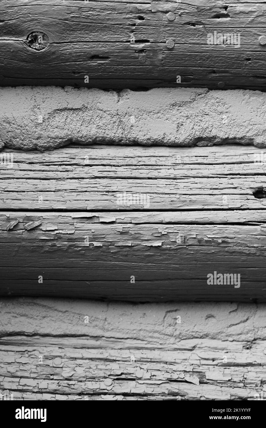 Full frame view of the wooden wall of a vintage log cabin in a black and white monochrome. Stock Photo