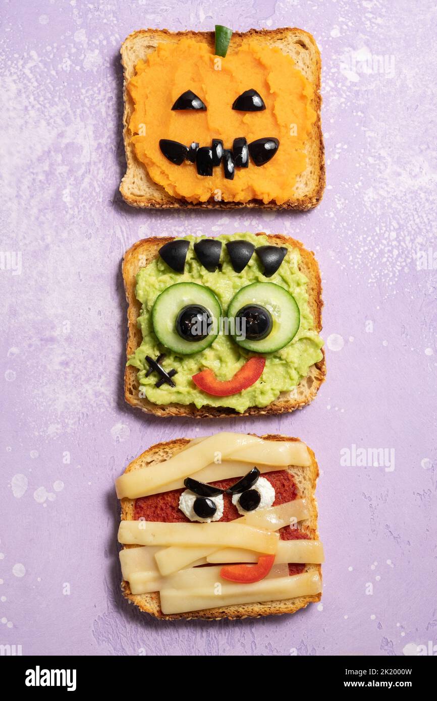 Fun Halloween monsters toasts. Happy Holiday. Avocado, pumpkin and cheese Stock Photo