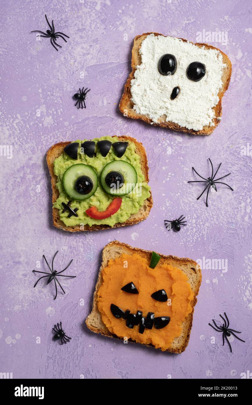 Fun Halloween monsters toasts. Happy Holiday. Avocado, pumpkin and cheese Stock Photo