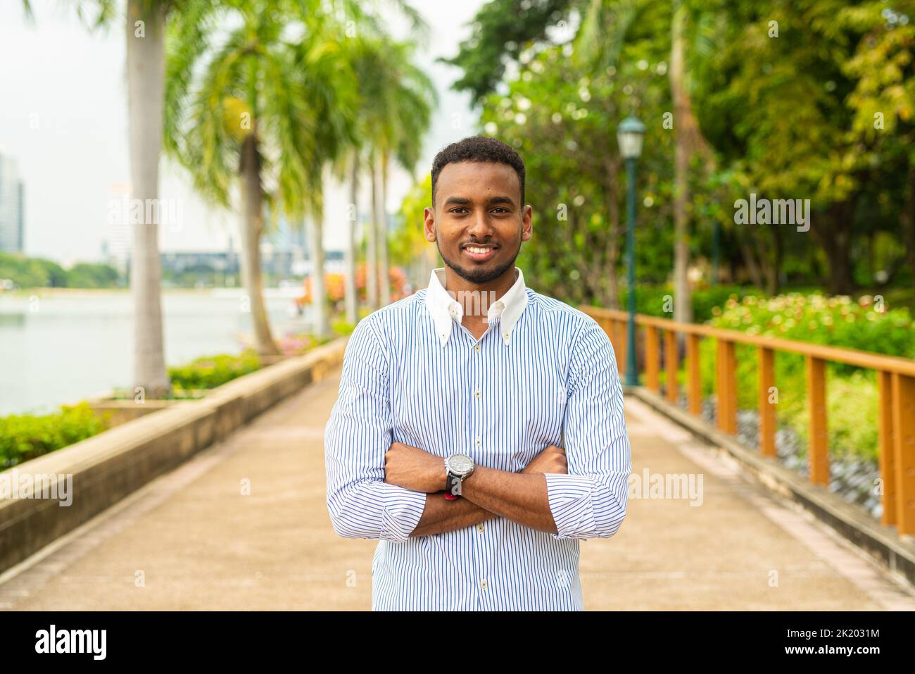 Portrait of handsome young black businessman at park outdoors during summer Stock Photo