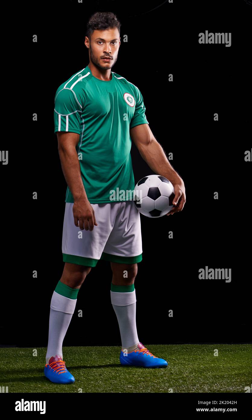 The beautiful game. Full length studio shot of a handsome young soccer player isolated on black. Stock Photo