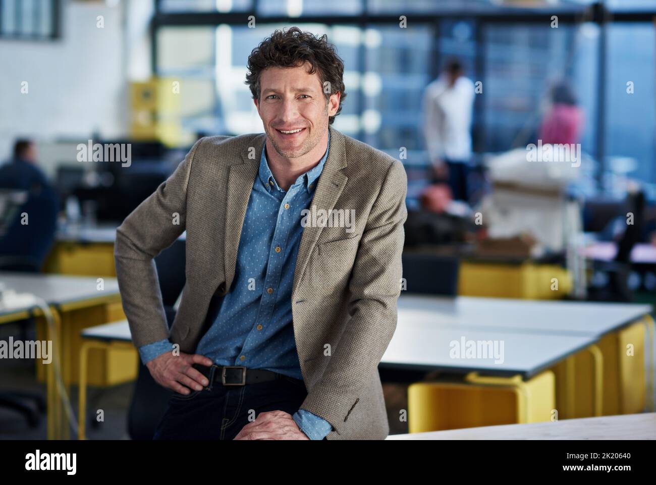 Contemporary corporate strategies. Candid image of a mature man sitting confidently in an open plan office space. Stock Photo