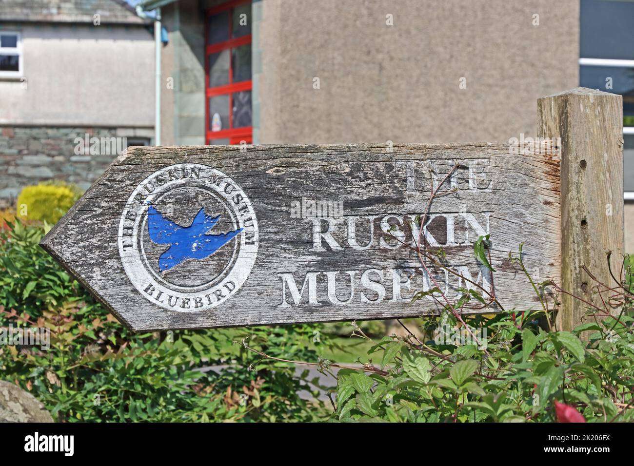 Wooden signpost showing way to the Ruskin Museum, Coniston Stock Photo