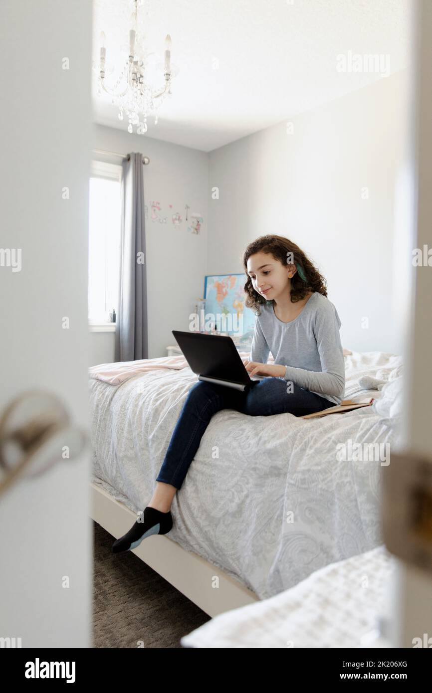 Girl using laptop on bed Stock Photo Alamy