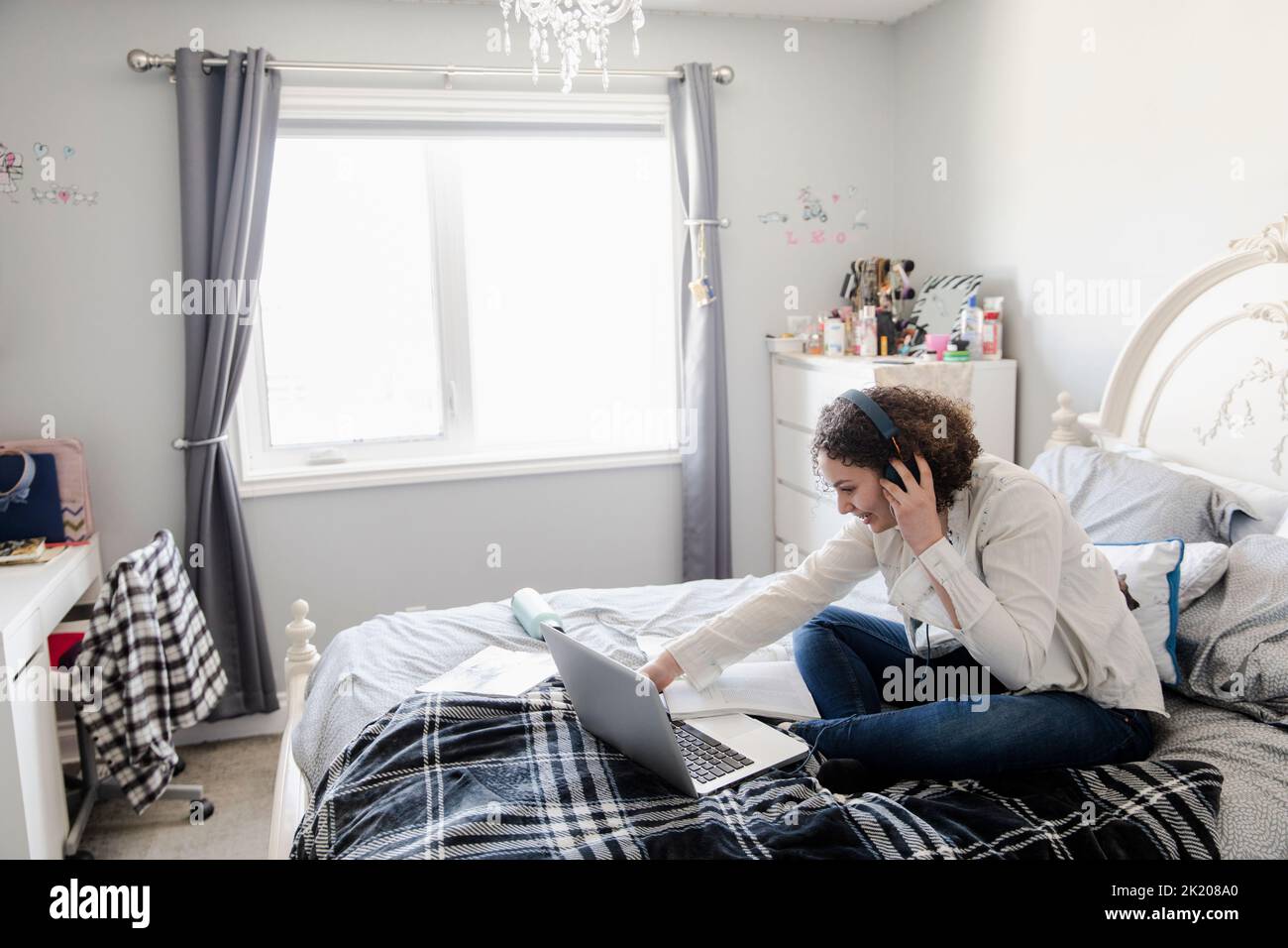 Teenage girl wearing headphones in bedroom Stock Photo Alamy